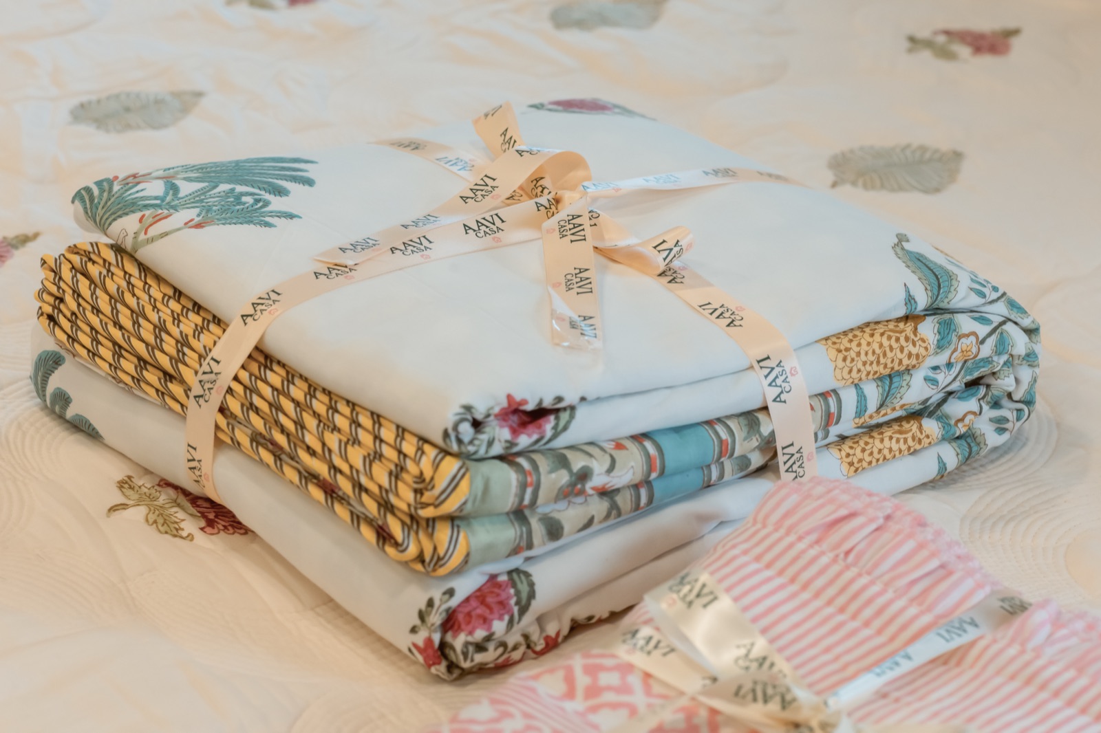 Ribbon-tied stack of block-print quilts